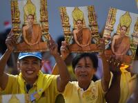 People hold portraits of Thailand's King Maha Vajiralongkorn as they wait for him and Queen Suthida to appear on the balcony of Suddhaisavarya Prasad Hall of the Grand Palace to grant a public audience on the final day of his royal coronation in Bangkok on May 6, 2019.  Lillian SUWANRUMPHA / AFP
