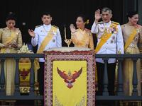 (From L to R) Thailand's Princess Sirivannavari Nariratana uses her mobile phone as her brother Prince Dipangkorn Rasmijoti, sister Princess Bajrakitiyabha Mahidol, father King Maha Vajiralongkorn and Queen Suthidawave to well-wishers from the balcony of Suddhaisavarya Prasad Hall. Jewel SAMAD / AFP