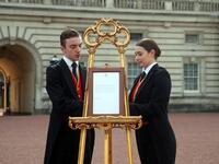 Footmen Stephen Kelly and Sarah Thompson set up an official notice on an easel at the gates of Buckingham Palace in London on May 6, 2019, announcing the birth of a son to Britain's Prince Harry, Duke of Sussex and Meghan, Duchess of Sussex. Yui Mok / POOL / AFP