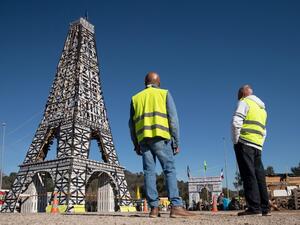 "Yellow Vest" movement protestors look at a 11,5 meter Eiffel Tower replica they made of 135 wood pallets on the roundabout of Le Luc, southeastern France. (AFP/ File Photo)