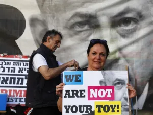 A woman holds a banner as Israeli opposition parties' supporters attend a rally against Prime Minister Benjamin Netanyahu on May 25, 2019 in the coastal city of Tel Aviv. (JACK GUEZ / AFP)