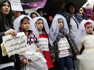 Young Lebanese girls hold placards as they participate in a march against early marriage in Beirut, March 2, 2019. (AFP / ANWAR AMRO)
