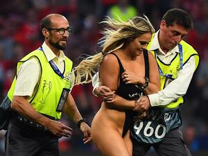 Stewards escort a pitch invader during the UEFA Champions League final football match between Liverpool and Tottenham Hotspur at the Wanda Metropolitano Stadium in Madrid on June 1, 2019.  GABRIEL BOUYS / AFP