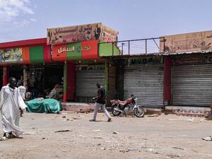Sudanese men walk past closed shops in the capital Khartoum on June 11, 2019, on the third day of a civil disobedience campaign launched by protest leaders after a crackdown on a weeks-long sit-in left dozens dead on June 3. (AFP)