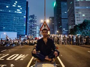 A protester (C) sits at the middle of Harcourt Road in Hong Kong after a protest against a controversial extradition law proposal in Hong Kong on June 12, 2019. (AFP/ File)
