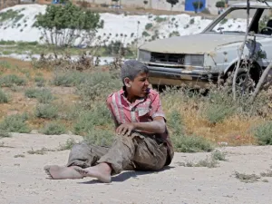 A young Syrian man sits on the ground after a bombing on an industrial area of Idlib, Northern Syria, on June 18, 2019. (AFP/ File Photo)