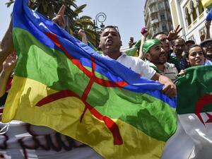 Algerian protesters wave the Amazigh (C) and national flags as they chant slogans during the weekly Friday demonstration in the capital Algiers on June 21, 2019. (AFP/ File Photo)