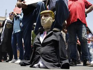 Palestinian demonstrators step on an effigy of US President Donald Trump during a protest against the US-sponsored Middle East economic conference that opens today in Bahrain, in the Israeli-occupied West Bank city of Nablus on June 25, 2019. (AFP/ File Photo)
