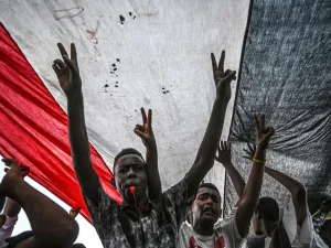 Sudanese protesters shout slogans and flash victory signs during a rally outside the army complex in Sudan's capital Khartoum. (AFP/ File Photo)