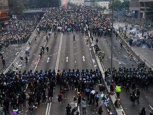 Police clash with protesters during a rally against a controversial extradition law proposal outside the government headquarters in Hong Kong (AFP)  