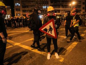 A protester holds a road sign as a shield following a march against a controversial extradition bill in Hong Kong on July 21, 2019. (VIVEK PRAKASH / AFP)