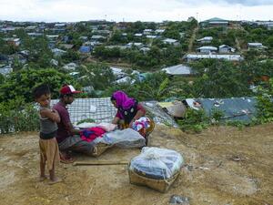 A Rohingya woman buy cloths from a vendor at Kutupalong refugee camp in Ukhia on July 24, 2019. (MUNIR UZ ZAMAN / AFP)