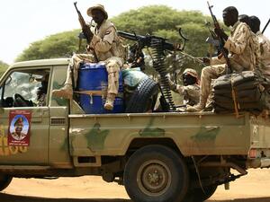 Sudanese members of the Rapid Support Forces, a paramilitary force backed by the Sudanese government to fight rebels and guard the Sudan-Libya border, ride in the back of a Toyota pickup truck. (AFP/ File Photo)