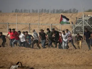 Palestinian demonstrators run away from the fence during protests along the border with Israel, east of Khan Yunis, in the southern Gaza Strip on July 12, 2019. (Mahmud Hams/AFP)