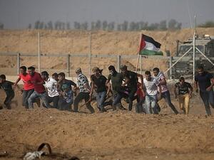 Palestinian demonstrators run away from the fence during protests along the border with Israel, east of Khan Yunis, in the southern Gaza Strip on July 12, 2019. (Mahmud Hams/AFP)