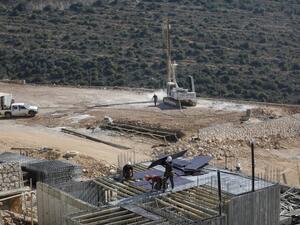Palestinian labourers work at a construction site in the Israeli settlement  (AFP)