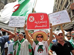 Algerian protesters hold posters as they demonstrate in Algiers on August 2, 2019, for the 24th consecutive Friday against the ruling class amid an ongoing political crisis in the country. (AFP)