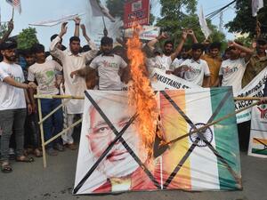 Pakistani activists of the "Youth Forum for Kashmir" group shout slogans as a a picture of Indian Prime Minister Narendra Modi and Indian flag is burned during a protest in Lahore on August 5, 2019. (AFP/ File Photo)