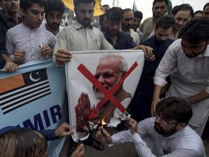 Students of Islami Jamiat-e-Talaba (IJT), a wing of religious political party Pakistan Jamaat-e-Islami (JI), burn a photograph of Indian Prime Minister Narendra Modi during a protest in Peshawar (AFP)