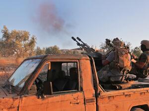 Fighters from the former al-Qaeda Syrian affiliate Hayat Tahrir al-Sham (HTS) fire an anti-aircraft gun mounted on a pickup truck in Syria's southern Idlib province on August 7, 2019. (Omar HAJ KADOUR / AFP)
