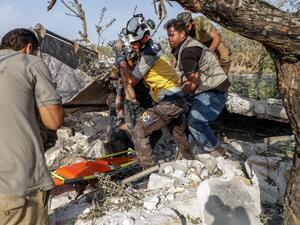 Syrians and members of Syrian Civil Defence recover a body from the rubble after a reported airstrike by regime planes on the town of Maaret Hurmah in the southern countryside of Syria's northwestern Idlib province, on August 14, 2019. (Abdullah Hammam / AFP)