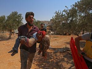 A Syrian carries the body of a child at the site of a reported regime air strike on the village of Deir Sharqi on the eastern outskirts of Maaret al-Numan in Syria's northern province of Idlib on August 17, 2019. (AFP/ File Photo)