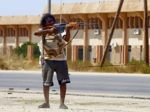 A fighter loyal to the internationally-recognised Government of National Accord (GNA) points his gun toward enemy lines during clashes with forces loyal to strongman Khalifa Haftar, in Espiaa. (AFP/ File Photo)
