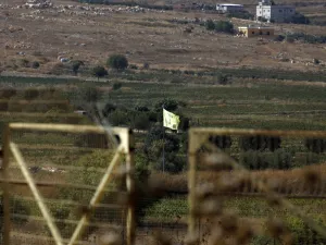 Northern Israeli town of Avivim shows a Hezbollah flag in the Lebanon village of Aitaroun (AFP)