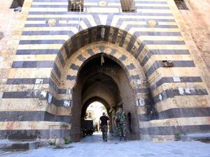 Syrian government soldiers walk through the entrance to the Khan al-Wazir market in Aleppo on September 16, 2016. (AFP/ File Photo)