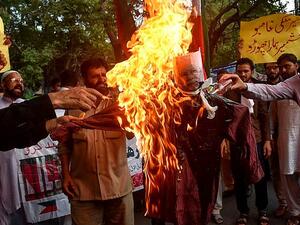 Protesters burn an effigy of Indian Prime Minister Narendra Modi during a protest in Lahore, Pakistan, where Muslims supported Kashmir's claim to special status  (AFP)
