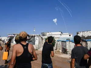 Men watch as tear gas canisters fired by the Turkish gendarmerie fall amidst clashes in a demonstration by displaced Syrians along the border with Turkey near the town of Atme in the northwestern Idlib province on August 30, 2019. (AFP/ File Photo)