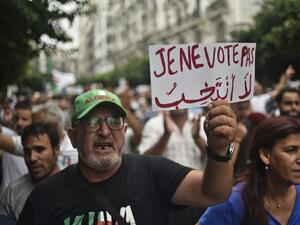 An Algerian protester holds a placard reading "I won't vote", during a demonstration against the ruling class in the capital Algiers on September 13, 2019, for the 30th consecutive Friday since the movement began. (AFP/ File Photo)