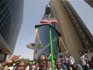 A Sudanese protester carries makeshift scales during a protest asking for the extradition of ousted former president Omar al-Bashir to the International Criminal Court in the capital Khartoum on September 19, 2019. (ASHRAF SHAZLY / AFP)