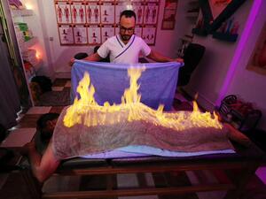 Massage therapist Abdel Rehim Saeid performs the fiery towel method to ease a patient's muscle pain in Gharbia, Egypt. (Twitter)