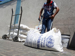 Palestinians receive their monthly food aid at a United Nations distribution center. (Shutterstock/ File Photo)