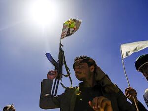A Yemeni man holds up a Kalashnikov assault rifle with a flag sticking from its barrel showing a picture of the Huthi rebel leader Abdulmalik al-Huthi, during a tribal meeting in the Huthi rebel-held capital Sanaa on September 21, 2019, as tribesmen donate rations and funds to fighters loyal to the Huthis along the fronts. (Mohammed HUWAIS / AFP)