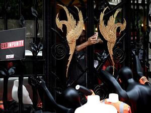 A man takes pictures of dummies with press armbands and jacket piled in front of the Saudi Consulate in Neuilly-Sur-Seine, west of Paris  (AFP)