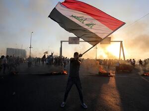 An Iraqi protester waves the national flag during a demonstration against state corruption, failing public services, and unemployment, in the Iraqi capital Baghdad on October 5, 2019. (AFP/ File Photo)