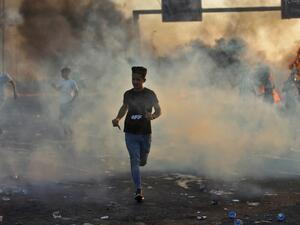 Iraqi demonstrators run amidst smoke from burning tyres during a demonstration against state corruption, failing public services, and unemployment, in the Iraqi capital Baghdad on October 5, 2019. (AFP/ File Photo)