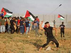 A Palestinian protester uses a slingshot to hurl stones during clashes with Israeli forces following a demonstration by the border fence between the Gaza Strip and Israel, east of Gaza City, on October 11, 2019. (SAID KHATIB / AFP)