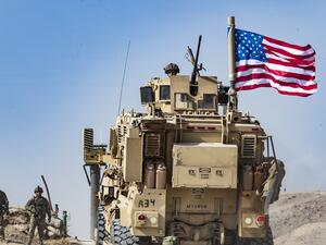 In this file photo taken on October 6, 2019 a US soldier sits atop an armoured vehicle during a demonstration by Syrian Kurds against Turkish threats next to a base for the US-led international coalition on the outskirts of Ras al-Ain town in Syria's Hasakeh province near the Turkish border. (Delil SOULEIMAN / AFP)