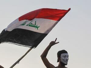 An Iraqi protester, wearing the Guy Fawkes mask, flashes the V for victory sign during ongoing anti-government demonstrations (AFP)