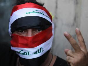 An Iraqi protester flashes the victory sign during ongoing anti-government demonstrations on al-Jumhuriya bridge which leads to the high-security Green Zone, in the capital Baghdad on November 2, 2019. Iraqi security forces clashed with anti-government protesters in the early hours of Saturday near the capital's Tahrir Square, leaving one demonstrator dead and dozens more wounded, medical sources said. AHMAD AL-RUBAYE / AFP