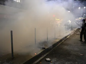 A bystander records footage with his mobile phone as firemen extinguish a burning barricade after a protest in the Tuen Mun district of Hong Kong on November 10, 2019. The international finance hub has been upended by five months of huge and increasingly violent rallies, but Beijing has refused to give in to most of the movement's demands. Philip FONG / AFP