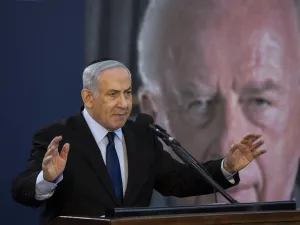 Israeli Prime Minister Benjamin Netanyahu speaks during a state memorial ceremony for former Israeli prime minister Yitzhak Rabin (backround) and his wife Leah, at Mount Herzl in Jerusalem on November 10, 2019.  (HEIDI LEVINE / POOL / AFP)
