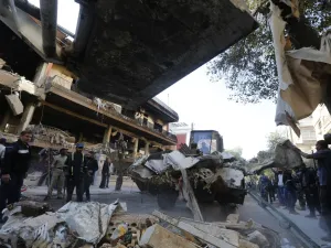 Syrian municipality workers clearing debris from building in Damascus' Mazze neighbourhood following an air strike (AFP)