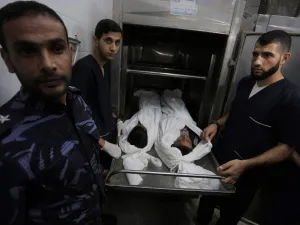 Palestinian police and morgue workers show the bodies of two of six members of the same family killed in an Israeli airstrike, at a morgue in central Gaza Strip's Deir al-Balah on November 14, 2019. Six members of the same family were killed in an Israeli airstrike on the southern Gaza Strip, the health ministry of the coastal Palestinian enclave said on November 14. The deaths bring the toll from Israeli strikes targeting Islamic Jihad militant sites to 32 since November 12, while 350 rockets have been fir