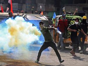 An Iraqi protester throws back a tear gas canister fired by security forces amid clashes at Baghdad's Khallani square during ongoing anti-government demonstrations on November 15, 2019. Iraq's political elite has come under renewed pressure in recent days from both the street and the international community to seriously address calls for reform. AHMAD AL-RUBAYE / AFP