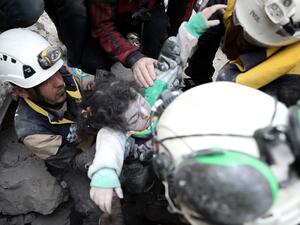 Syrian rescue workers known as the 'White Helmets' and residents remove body of a child from under the rubble of a building destroyed by a reported Russian airstrike on the village al-Barra in the southern countryside of Syria's northern Idlib province on November 15, 2019. (Omar HAJ KADOUR / AFP)