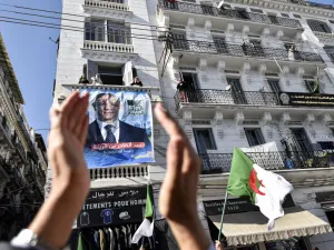A supporters of Abdelkader Bengrina, former Algerian tourism minister and presidential candidate for the El-Bina (Construction) Islamist party, applauds outside his electoral campaign headquarters in the capital Algiers on November 17, 2019. (RYAD KRAMDI / AFP)